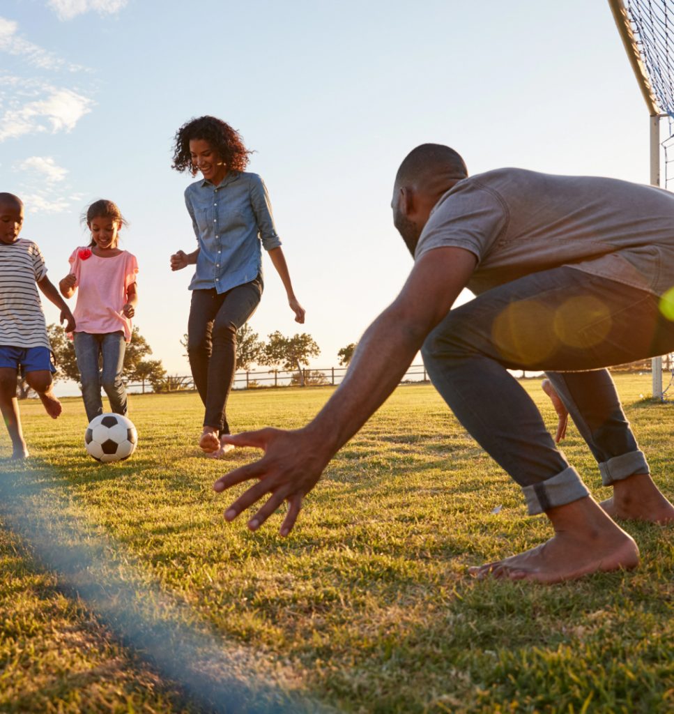 A family engages in a lively soccer match on a green field, highlighting their bond and enthusiasm for the sport.